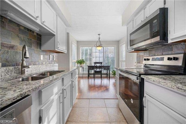 kitchen with sink, decorative light fixtures, stainless steel appliances, and white cabinets