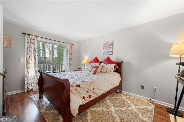 bedroom with dark hardwood / wood-style floors and access to exterior