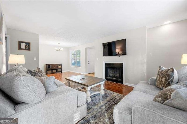 living room with a notable chandelier and wood-type flooring