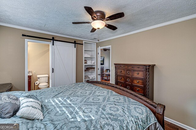 bedroom featuring a barn door, a textured ceiling, ceiling fan, and crown molding