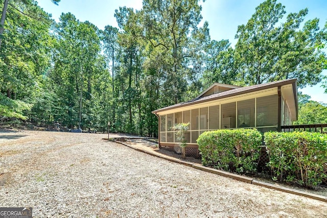 exterior space featuring gravel driveway and a sunroom