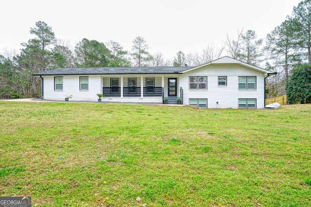 rear view of property with a porch and a lawn