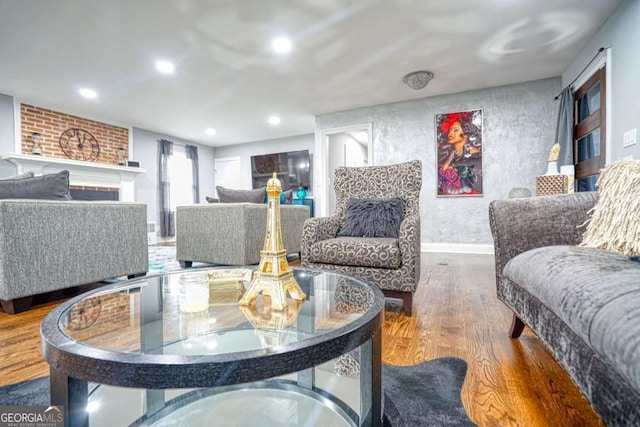 living area featuring baseboards, a fireplace, wood finished floors, and recessed lighting