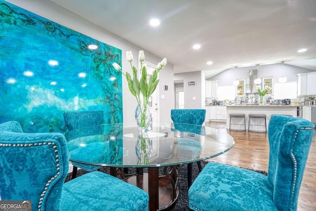 dining space featuring lofted ceiling, wood finished floors, and recessed lighting