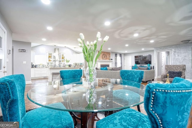 dining area with a fireplace, wood finished floors, and recessed lighting