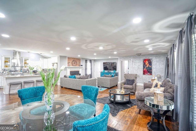 living area featuring a fireplace, wood finished floors, and recessed lighting