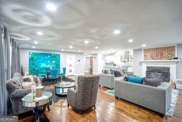 living area with recessed lighting, wood finished floors, and a glass covered fireplace