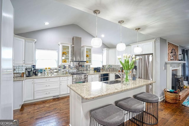 kitchen with island range hood, dark wood-style flooring, a sink, white cabinetry, and appliances with stainless steel finishes