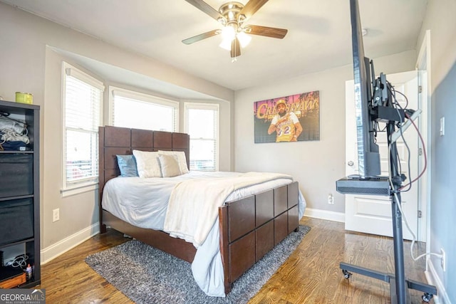 bedroom with ceiling fan, baseboards, and wood finished floors