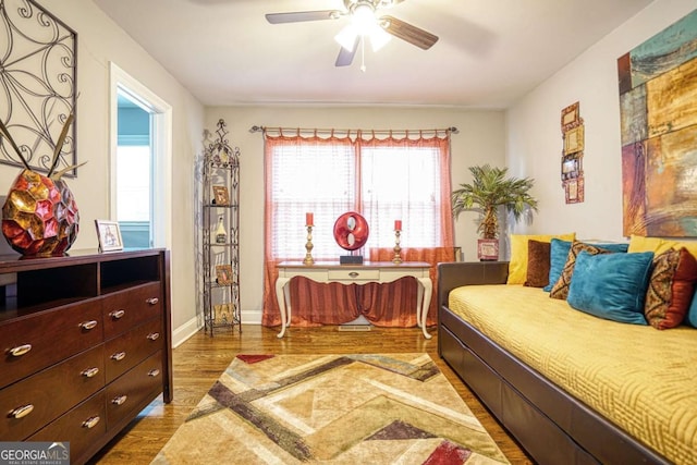 bedroom with ceiling fan, baseboards, and wood finished floors