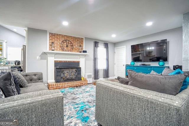 living room with a brick fireplace, vaulted ceiling, and recessed lighting