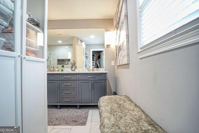 full bathroom with a stall shower, marble finish floor, a sink, and double vanity