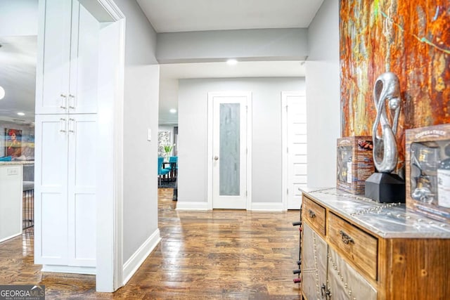 corridor featuring dark wood-style floors and baseboards