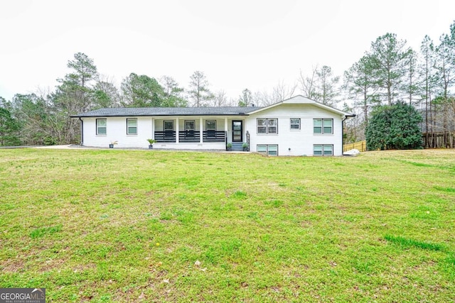 rear view of property featuring a lawn