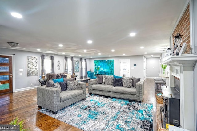 living room with dark wood-style floors, baseboards, a fireplace, and recessed lighting