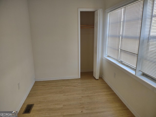 unfurnished bedroom featuring light hardwood / wood-style floors and a closet