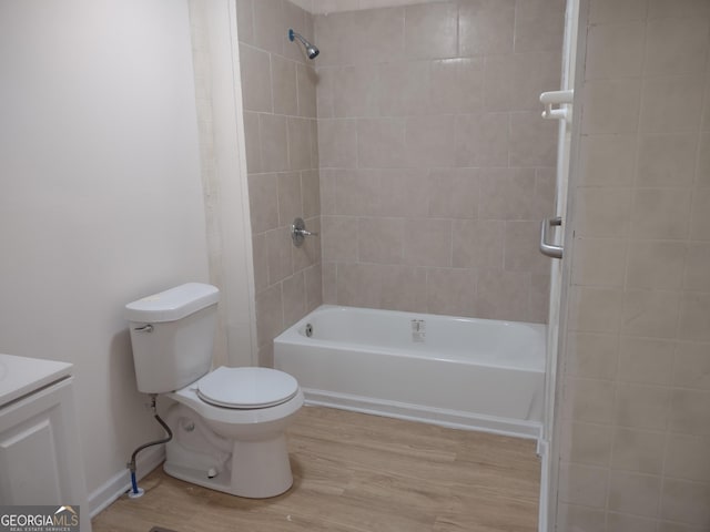 full bathroom featuring vanity, toilet, tiled shower / bath combo, and hardwood / wood-style floors