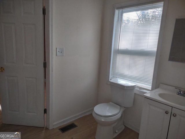 bathroom with vanity, wood-type flooring, and toilet