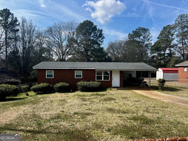 ranch-style home with a yard and a carport