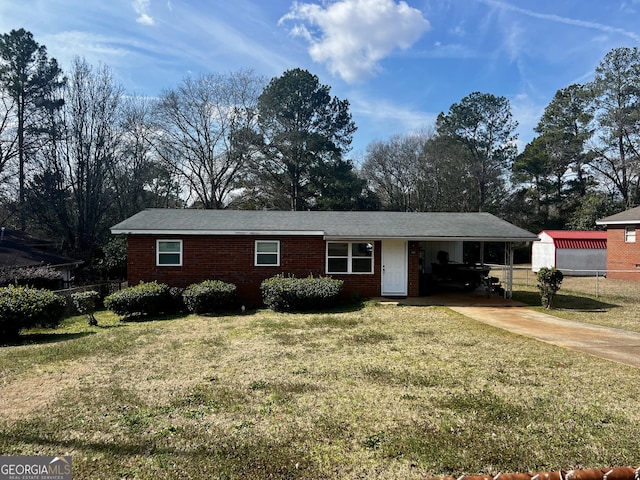 ranch-style home featuring an attached carport, a front yard, and fence