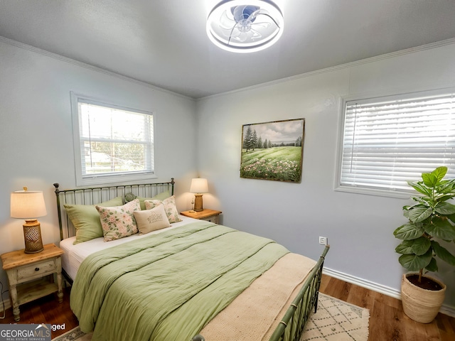 bedroom featuring crown molding, baseboards, and wood finished floors