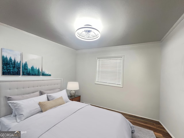 bedroom with crown molding, wood finished floors, and baseboards