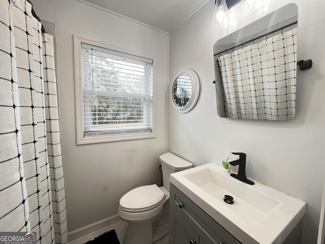 bathroom with curtained shower, toilet, vanity, and baseboards