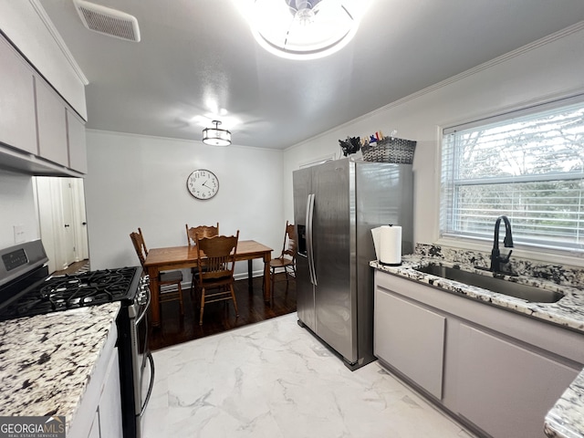 kitchen with crown molding, visible vents, appliances with stainless steel finishes, and a sink