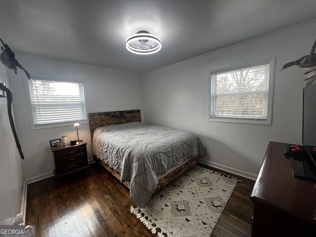 bedroom featuring multiple windows, baseboards, and wood finished floors