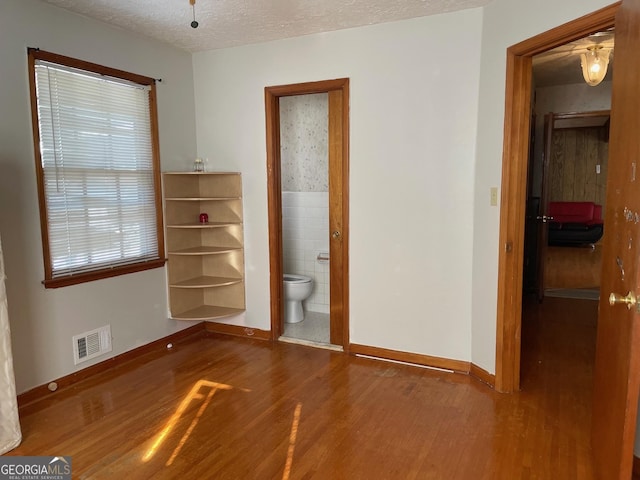 unfurnished room with hardwood / wood-style floors and a textured ceiling