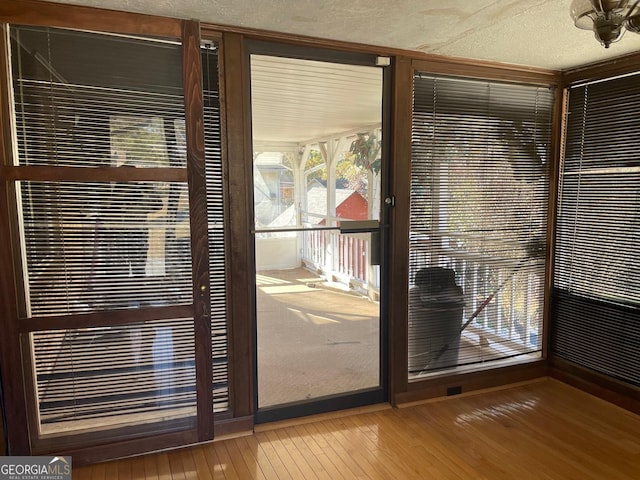 doorway to outside featuring hardwood / wood-style flooring and a textured ceiling