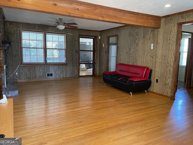 interior space featuring ceiling fan, beamed ceiling, and light wood-type flooring