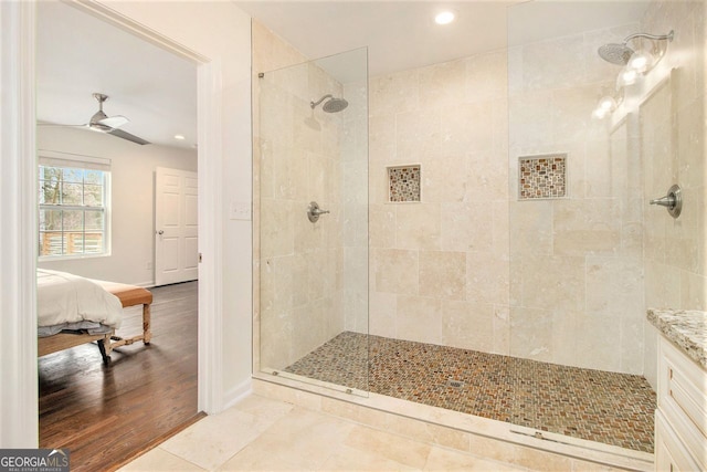 bathroom featuring tile patterned flooring, ceiling fan, and tiled shower