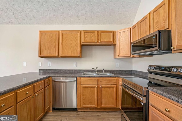 kitchen with sink, dark wood-type flooring, a textured ceiling, and appliances with stainless steel finishes