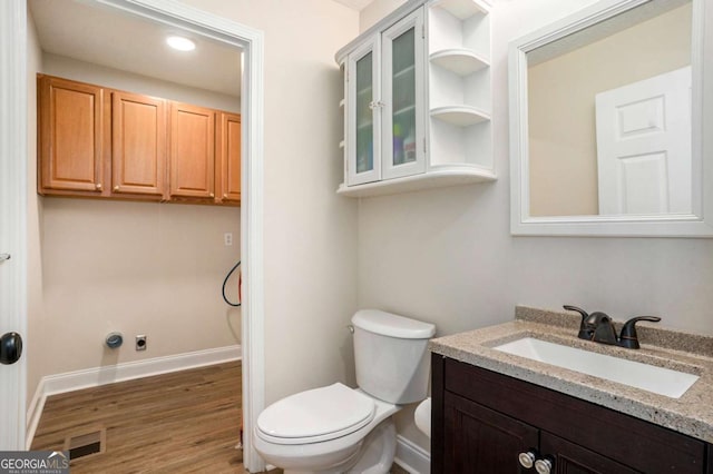 bathroom featuring vanity, hardwood / wood-style flooring, and toilet