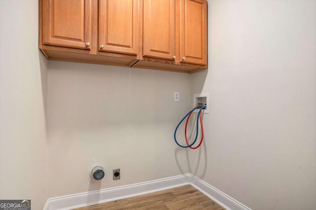 washroom featuring cabinets, hookup for a washing machine, hardwood / wood-style floors, and electric dryer hookup