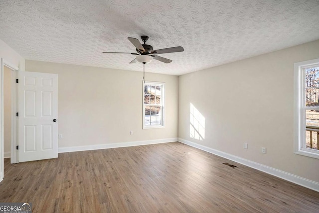 spare room with ceiling fan, hardwood / wood-style floors, and a textured ceiling