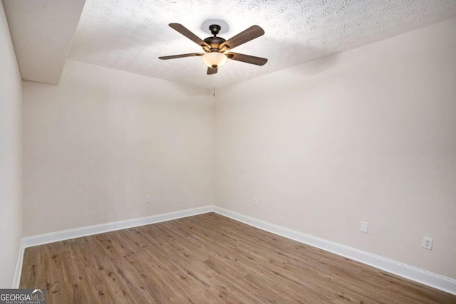 unfurnished room featuring ceiling fan, wood-type flooring, and a textured ceiling