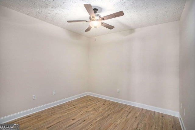 unfurnished room featuring ceiling fan, wood-type flooring, and a textured ceiling