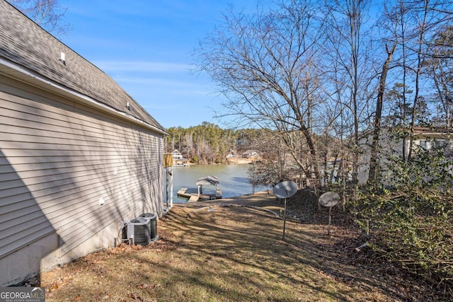 exterior space with cooling unit and a water view