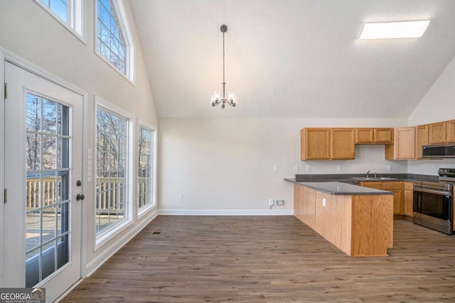 kitchen featuring pendant lighting, appliances with stainless steel finishes, dark hardwood / wood-style floors, kitchen peninsula, and a chandelier