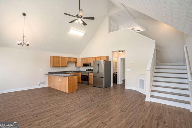 kitchen featuring appliances with stainless steel finishes, a center island, dark hardwood / wood-style flooring, and decorative light fixtures