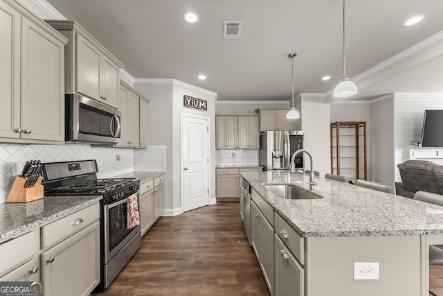 kitchen featuring pendant lighting, sink, appliances with stainless steel finishes, gray cabinetry, and an island with sink