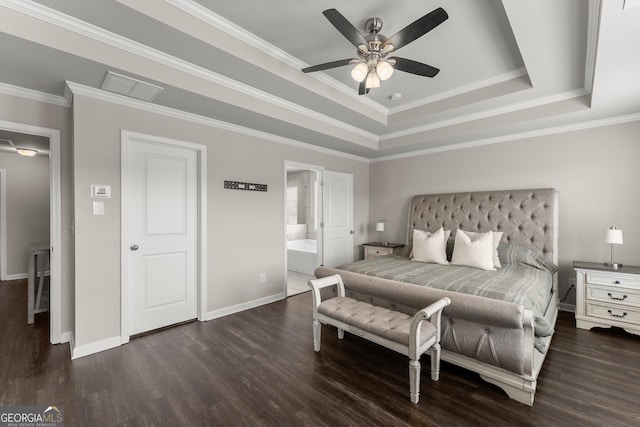 bedroom with crown molding, ensuite bath, dark hardwood / wood-style floors, and a raised ceiling