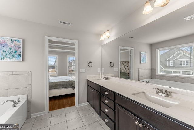 bathroom with tile patterned flooring, a bath, vanity, and plenty of natural light