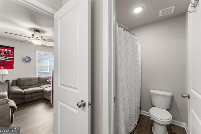 bathroom featuring hardwood / wood-style flooring, ceiling fan, and toilet