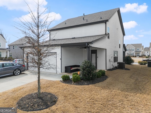 view of property exterior featuring central AC, a garage, and a lawn