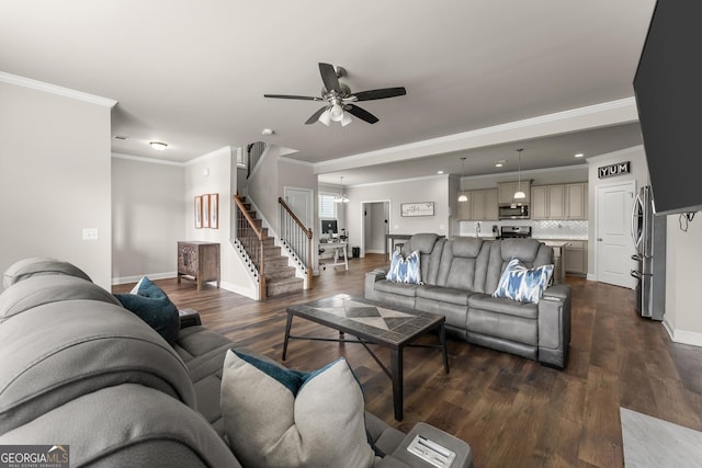 living room featuring dark hardwood / wood-style flooring, ceiling fan with notable chandelier, and ornamental molding