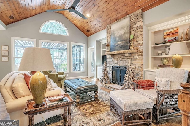 living room with a stone fireplace, wood-type flooring, built in features, and wooden ceiling