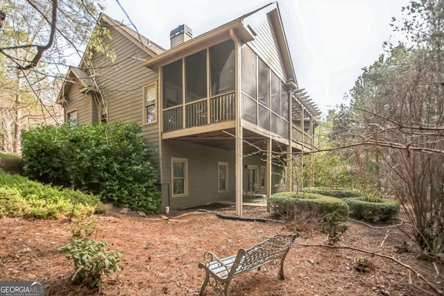 rear view of house featuring a sunroom and a pergola